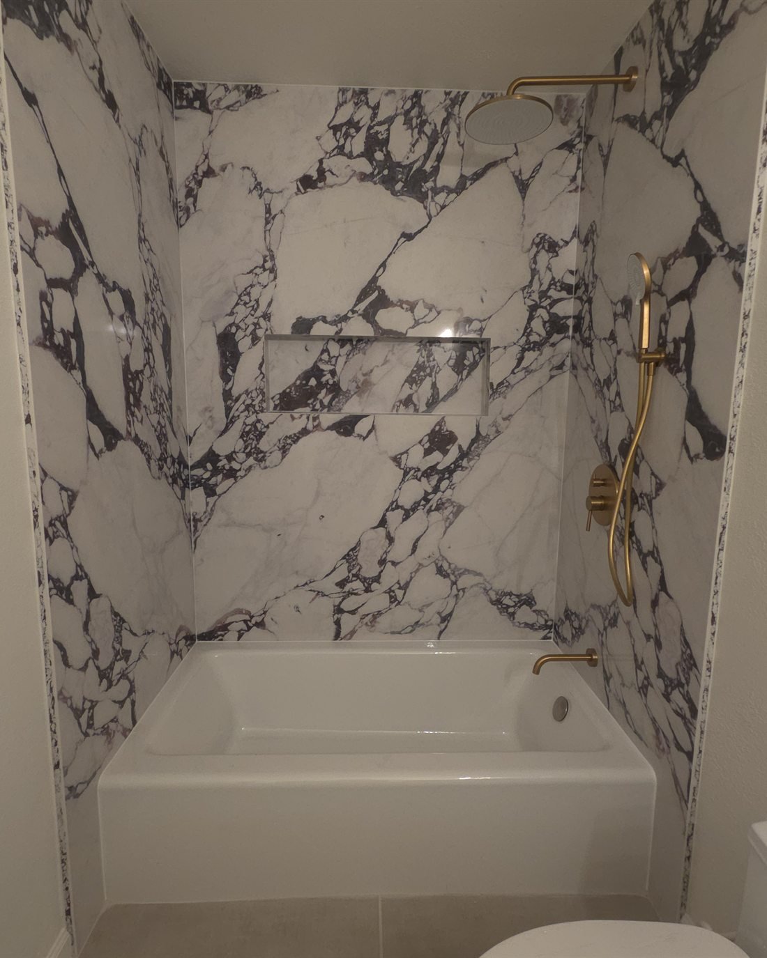 Calacatta Viola marble shower with brushed brass fixtures