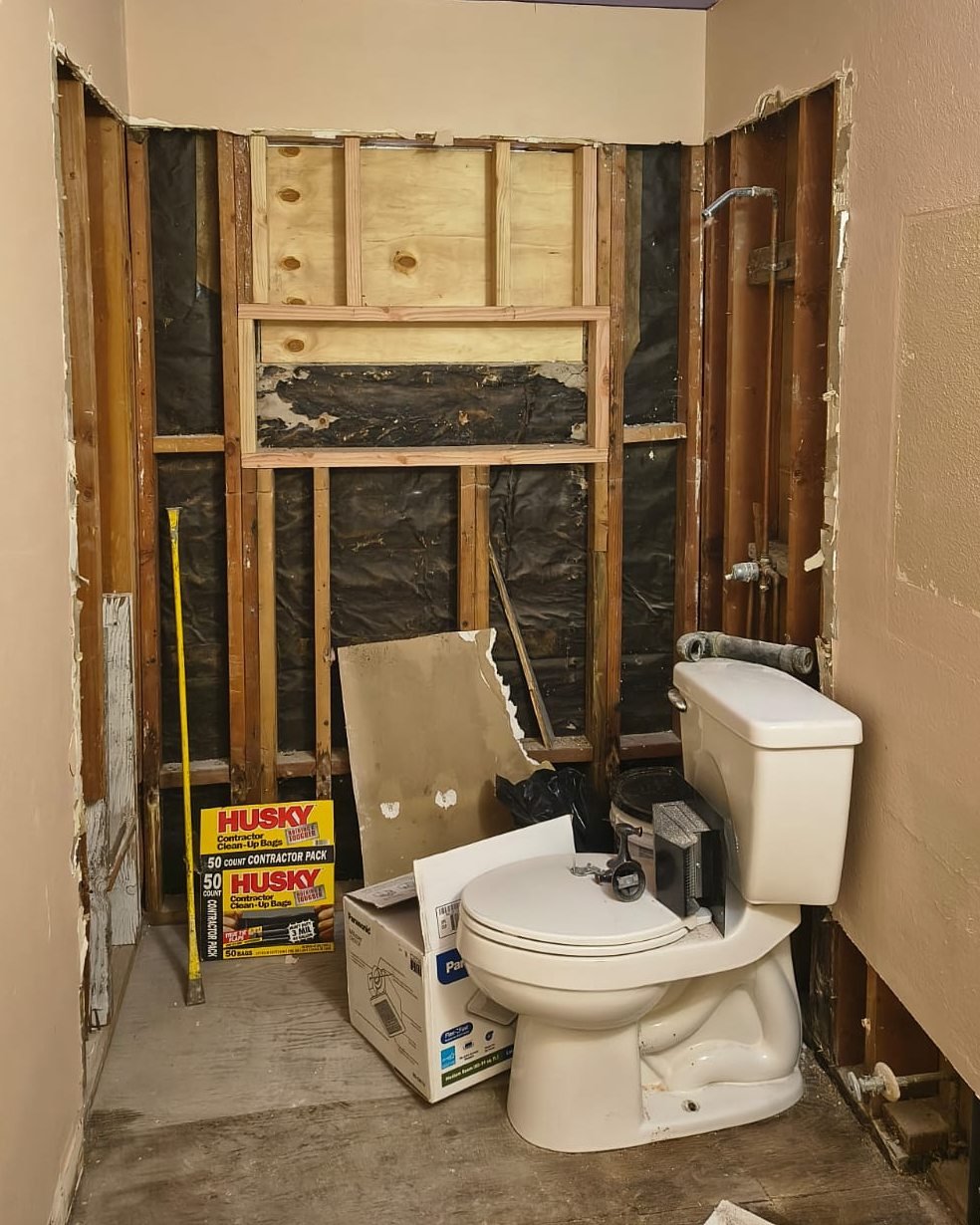 Bathroom before — wall opened to the studs, new niche framing in place