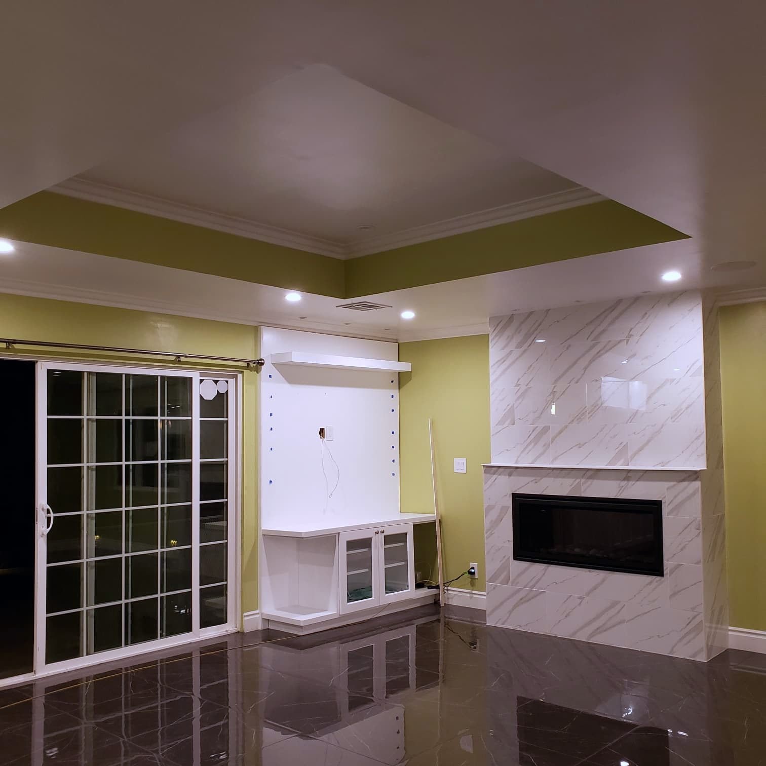 Open living room with linear marble fireplace and built-in cabinetry